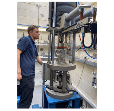 Figure 2. Lowering the pressure vessel down over the CT specimen, loaded and instrumented for testing