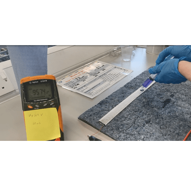 Figure 3. Example of hydraulic test. The Wrapsense sensor (white) is laid over the spill blanket and connected to the multimeter using clamps. A reading of 95.74 kOhm is displayed